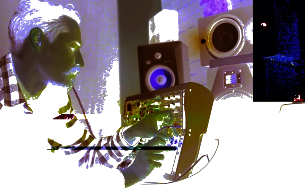 Giovanni Barbieri playing a modular synthesizer beside studio monitors — glitch-processed portrait